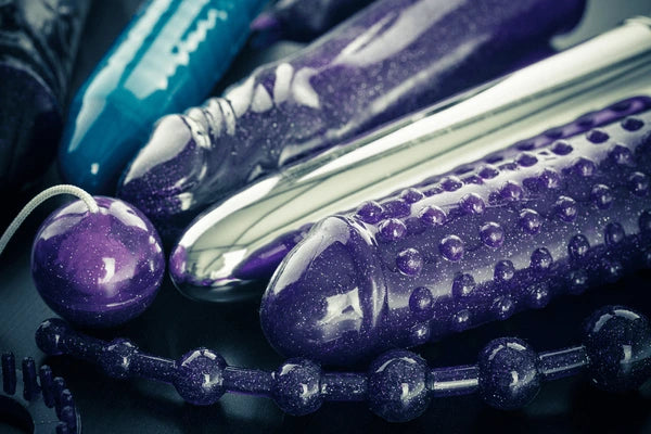 Collection de sextoys modernes incluant godemichés texturés, boules de geisha et perles anales pour jeux sexuel et stimulation intime.