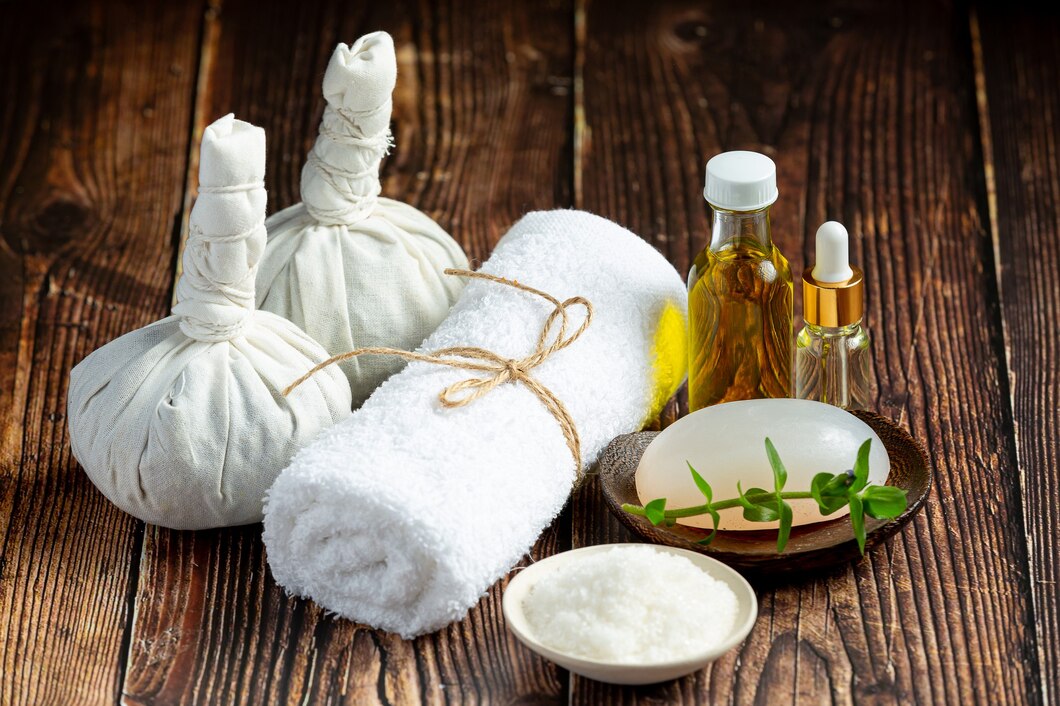 Compresses en tissu, huiles essentielles, savon naturel et sel de bain pour massage relaxant en spa.