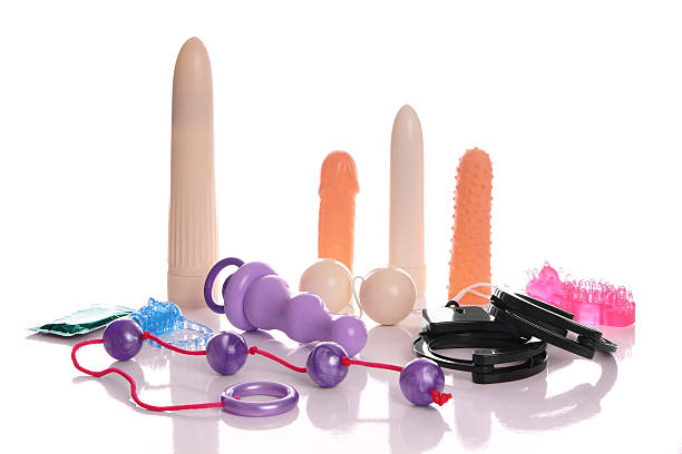 Collection de sextoys variés incluant vibromasseurs, boules de geisha, anneaux et accessoires érotiques sur fond blanc.