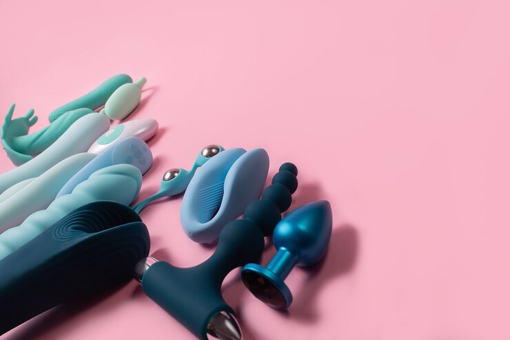 Collection de jouets sexuels pour hommes et femmes modernes en silicone bleu et turquoise sur fond rose.